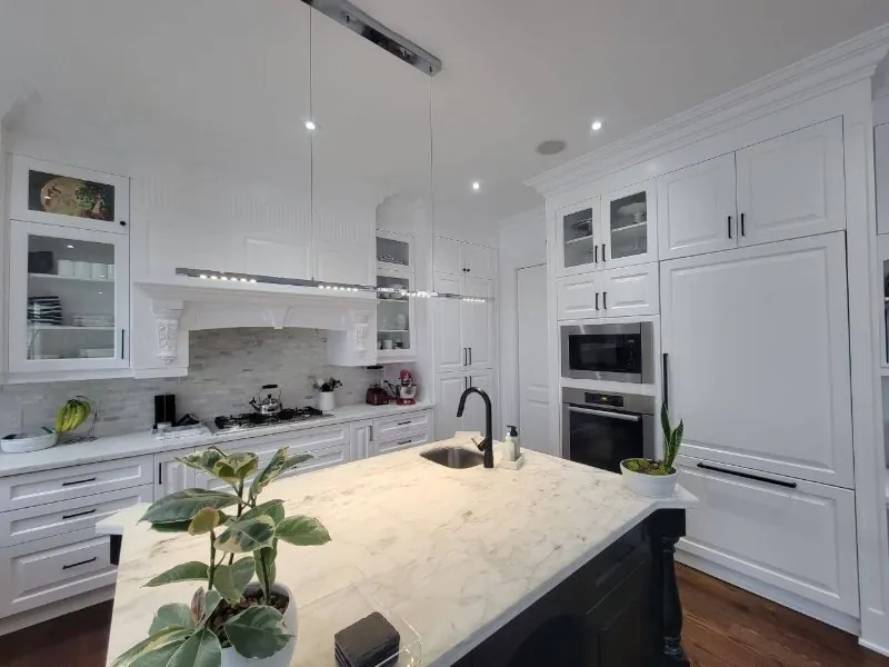 Bright classic white kitchen with a marble island, shaker cabinets and stainless appliances after real estate photo enhancement (original, before AI enhancement)